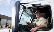 Truck driver sitting in cab of semi-truck